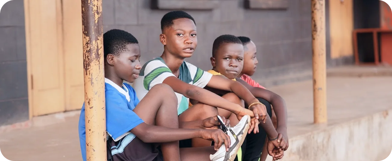 Young people sitting together on the steps outside a building